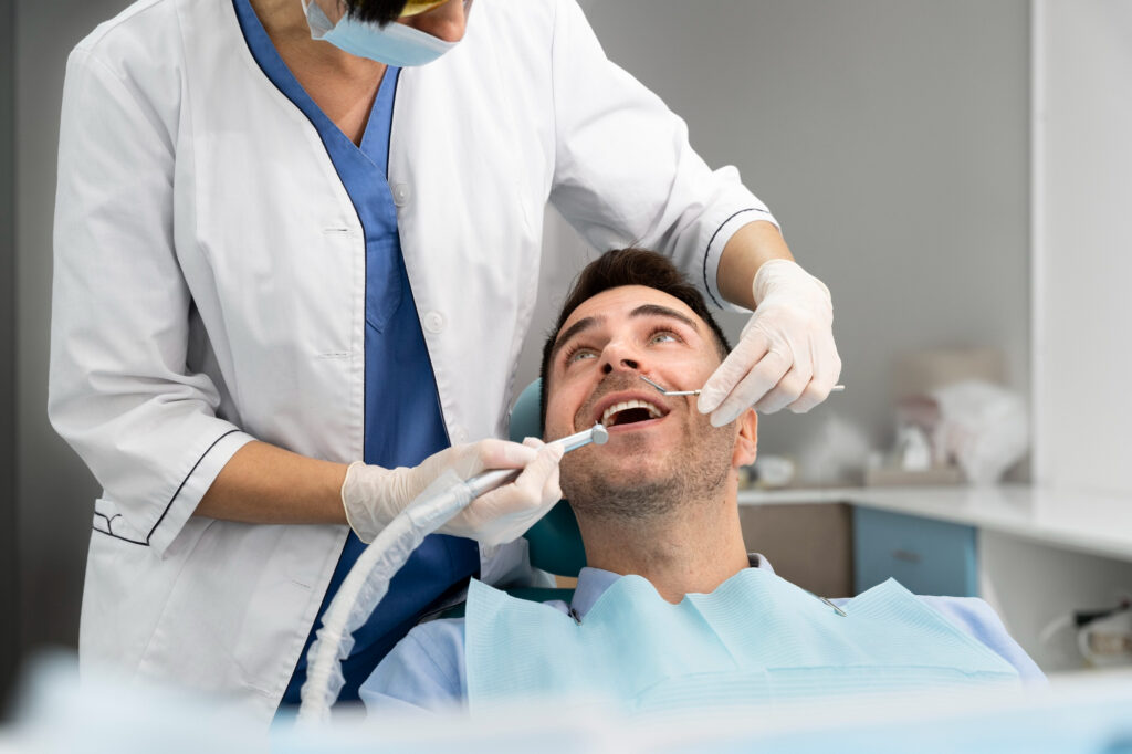 A dentist inspecting and working on a smiling patient just before a planned dental implant surgery