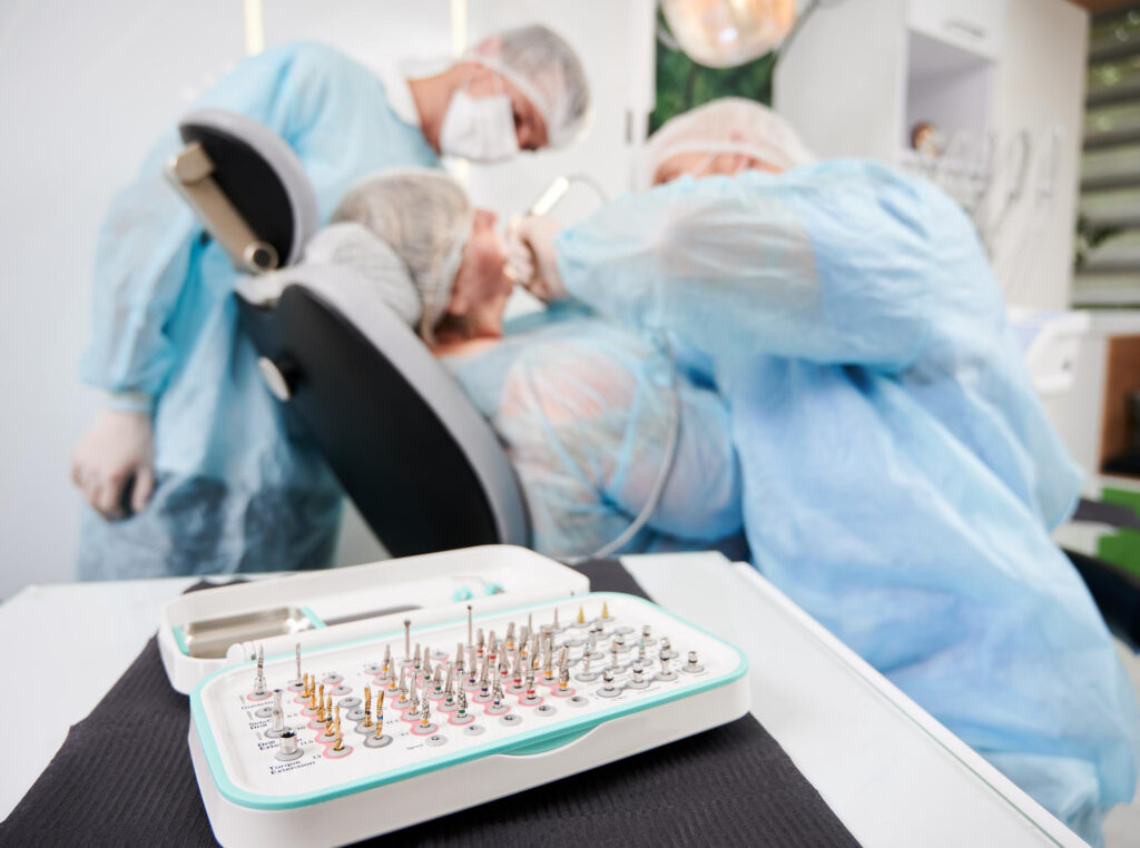 An implant surgery performed in the background with a set of implants and tools in the foreground